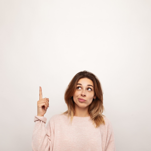 woman pointing upward looking unsure